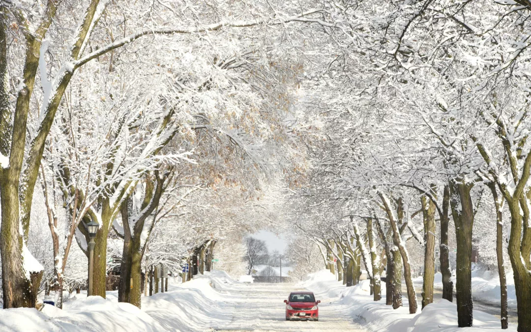 Red car driving down a snowy road